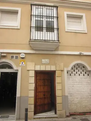 a building with a large wooden door and a window at Central Apartment in Sanlucar in Sanlúcar de Barrameda