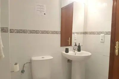 a white bathroom with a toilet and a sink at Central Apartment in Sanlucar in Sanlúcar de Barrameda