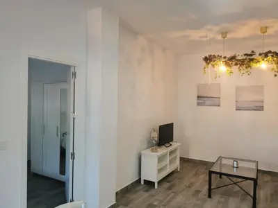 a white room with a table and a mirror at Apartamentos Sanlúcar Beach 4 y 5 in Sanlúcar de Barrameda