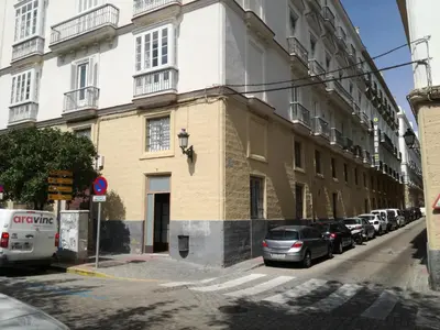 a building with cars parked on the side of a street at Centro Histórico con parking Cádiz in Cádiz