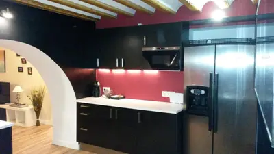 a kitchen with a refrigerator and a red wall at Centro Histórico con parking Cádiz in Cádiz