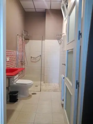 a bathroom with a toilet and a glass shower at Centro Histórico con parking Cádiz in Cádiz