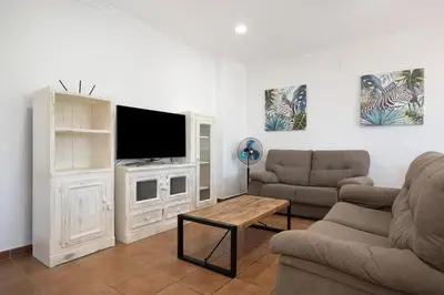 a living room with a couch and a tv at Vivienda Rural El chiclanero in Conil de la Frontera