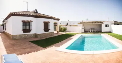a backyard with a swimming pool and a house at Vivienda Rural El chiclanero in Conil de la Frontera