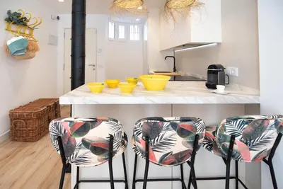 a kitchen with two bar stools and yellow bowls at SibsSanlucar MARITIMO-1ª Linea de Playa in Sanlúcar de Barrameda
