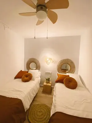 a bedroom with two beds and a ceiling fan at SibsSanlucar MARITIMO-1ª Linea de Playa in Sanlúcar de Barrameda