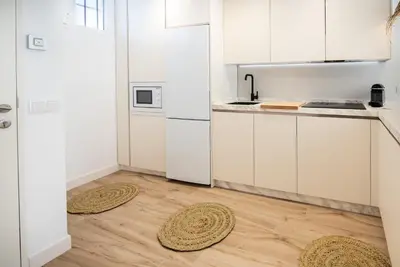 a kitchen with white cabinets and two mats on the floor at SibsSanlucar MARITIMO-1ª Linea de Playa in Sanlúcar de Barrameda