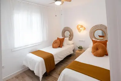 two beds in a room with two mirrors at SibsSanlucar MARITIMO-1ª Linea de Playa in Sanlúcar de Barrameda