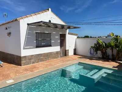 a villa with a swimming pool in front of a house at Casita Rural CONIL in Conil de la Frontera