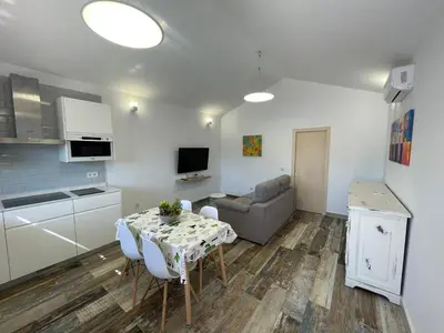 a kitchen and living room with a table and a couch at Casita Rural CONIL in Conil de la Frontera