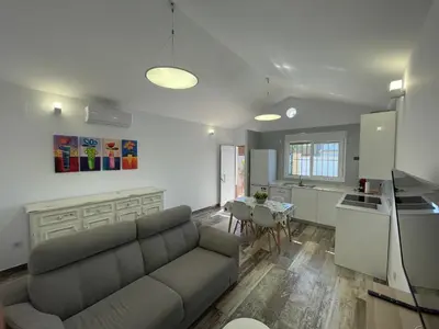 a living room with a couch and a kitchen with a table at Casita Rural CONIL in Conil de la Frontera