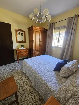 a bedroom with a bed and a chandelier at El Arrabal de la Barrosa in Chiclana de la Frontera