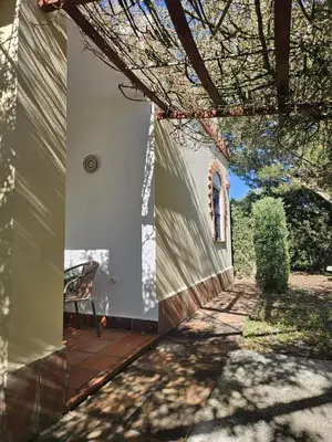 an outside view of a house with a chair on a patio at El Arrabal de la Barrosa in Chiclana de la Frontera