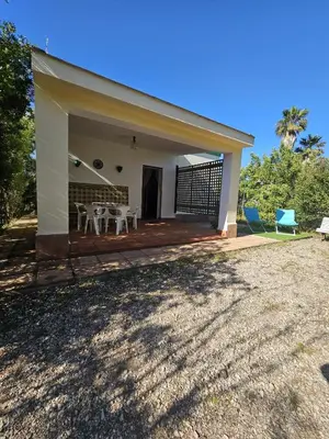 a house with a porch with a table and chairs at El Arrabal de la Barrosa in Chiclana de la Frontera