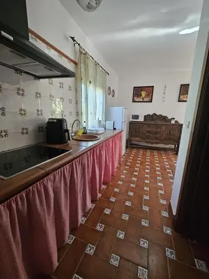 a kitchen with a counter top with red curtains at El Arrabal de la Barrosa in Chiclana de la Frontera