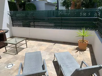 a patio with two chairs and a table and a plant at Apartamento Galeón - Ole Solutions in El Puerto de Santa María