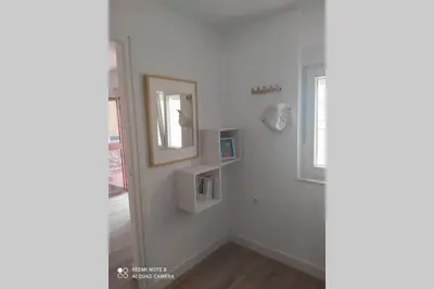 a white room with a mirror and a window at Atico con terraza en San Fernando (Cádiz) in San Fernando