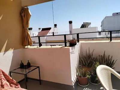 a balcony with a table and some plants on it at Atico con terraza en San Fernando (Cádiz) in San Fernando