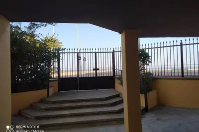 a gate on a balcony with stairs and a fence at Apartamento en primera línea de playa in Sanlúcar de Barrameda