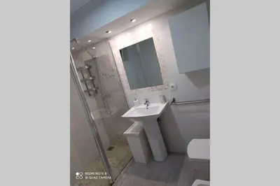 a white bathroom with a sink and a shower at Apartamento en primera línea de playa in Sanlúcar de Barrameda
