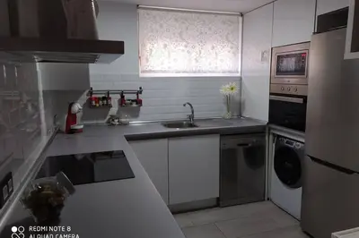 a small kitchen with a sink and a dishwasher at Apartamento en primera línea de playa in Sanlúcar de Barrameda