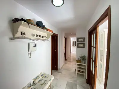 a hallway with white walls and tile floors and a door at MAGNÍFICO ÁTICO PLENO CENTRO. Terraza 60m. Climatizado, Garaje in Sanlúcar de Barrameda