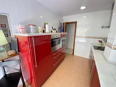 a kitchen with a red refrigerator and a red stove at MAGNÍFICO ÁTICO PLENO CENTRO. Terraza 60m. Climatizado, Garaje in Sanlúcar de Barrameda