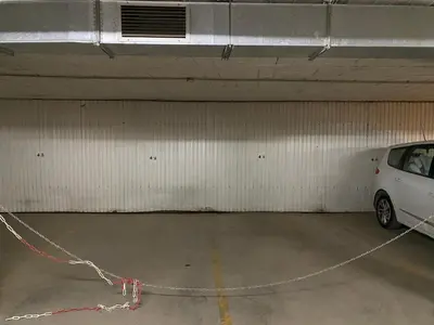 a parking garage with a white car parked in it at MAGNÍFICO ÁTICO PLENO CENTRO. Terraza 60m. Climatizado, Garaje in Sanlúcar de Barrameda