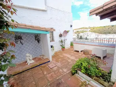 a patio with a dog sitting on a wall at Casa Jaruf CENTRO HISTÓRICO Parking Gratuito Patio petfriendly in Arcos de la Frontera