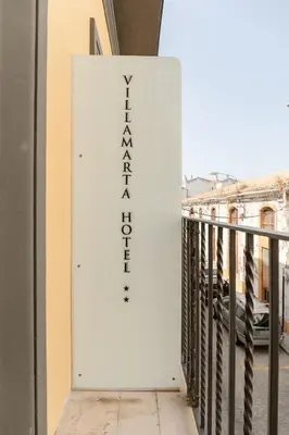 a white sign on the side of a balcony at Villamarta Boutique Rooms in Jerez de la Frontera