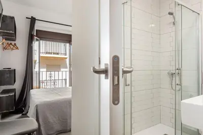 a bathroom with a shower with a glass door at Villamarta Boutique Rooms in Jerez de la Frontera