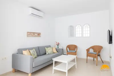 a living room with a gray couch and two chairs at Green Home by Cadiz Time in Cádiz