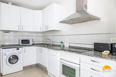 a kitchen with white cabinets and a washer and dryer at Green Home by Cadiz Time in Cádiz