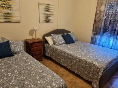 a bedroom with two beds and a night stand at VACACIONES DE LUJO.CHALET PISCINA Y PLAYA.EL PUERTO in El Puerto de Santa María