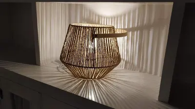 a wicker chair sitting on a table with a light at Playa Victoria Ha Apartment in Cádiz