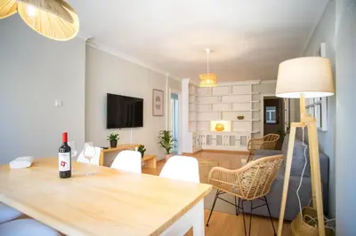 a dining room and living room with a table and chairs at Playa Victoria Ha Apartment in Cádiz