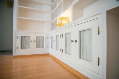 a hallway with white cabinets and a wood floor at Playa Victoria Ha Apartment in Cádiz