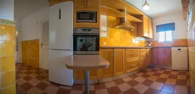 a kitchen with a refrigerator and a table in it at Playa Victoria Ha Apartment in Cádiz
