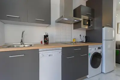 a kitchen with a white refrigerator and a washer at Apartamentos La BRUJULA by CadizRentals in Cádiz
