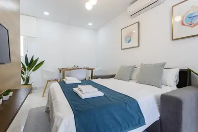 a white bedroom with a large bed with towels on it at Apartamentos La BRUJULA by CadizRentals in Cádiz