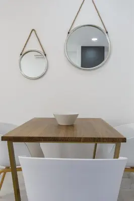 a wooden table with two mirrors on the wall at Apartamentos La BRUJULA by CadizRentals in Cádiz