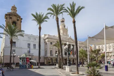 a group of palm trees in front of a building at Apartamentos La BRUJULA by CadizRentals in Cádiz