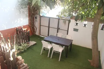 a patio with a table and chairs and a tree at Casa en zona tranquila y cerca de playa virgen in San Fernando