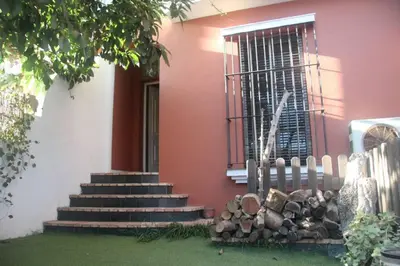 a house with stairs and a window and a pile of logs at Casa en zona tranquila y cerca de playa virgen in San Fernando
