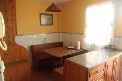 a kitchen with a table and a bench and a window at Casa en zona tranquila y cerca de playa virgen in San Fernando
