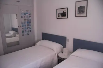 a bedroom with two beds and a mirror at Casa en zona tranquila y cerca de playa virgen in San Fernando