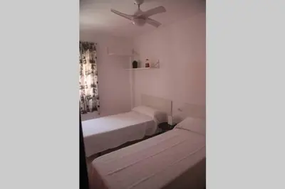 a bedroom with two beds and a ceiling fan at Casa en zona tranquila y cerca de playa virgen in San Fernando