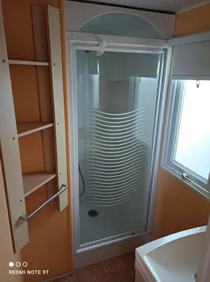a glass shower in a bathroom next to a sink at Bungalows Buda Beach in Sanlúcar de Barrameda