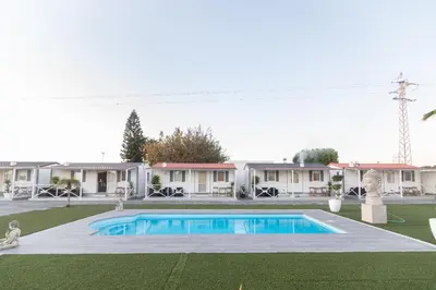 a swimming pool in the yard of a house at Bungalows Buda Beach in Sanlúcar de Barrameda
