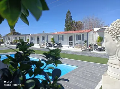 a house with a pool in front of it at Bungalows Buda Beach in Sanlúcar de Barrameda